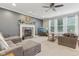 Inviting living room boasts fireplace, plush seating, a ceiling fan, and abundant natural light at 11844 Pine Meadow Cir, Fishers, IN 46037