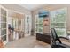 Bright office space with french doors and modern decor including a wall-mounted TV and natural light at 11844 Pine Meadow Cir, Fishers, IN 46037