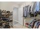 Organized walk-in closet with shelving for shoes, hanging rods for clothing, and an open doorway to more storage at 11844 Pine Meadow Cir, Fishers, IN 46037