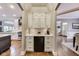 This home features a bar area with white cabinets and drawers, a wine cooler, and a quartz countertop at 12437 Meeting House Rd, Carmel, IN 46032