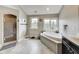 Well-lit bathroom featuring soaking tub, shower, and gray tile flooring at 12437 Meeting House Rd, Carmel, IN 46032