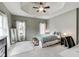 Bedroom with neutral tones features a tray ceiling, carpet, and large windows at 12437 Meeting House Rd, Carmel, IN 46032