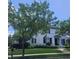 Beautiful white home with black shutters and a manicured lawn and landscaping at 12437 Meeting House Rd, Carmel, IN 46032