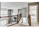 Bright hallway with wood and iron banister overlooking the open floor plan and fireplace at 12437 Meeting House Rd, Carmel, IN 46032