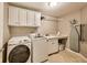 Well-organized laundry room featuring a washer, dryer, sink, and ample storage space at 12437 Meeting House Rd, Carmel, IN 46032