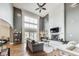 Spacious living room with soaring ceilings, a cozy fireplace, and lots of natural light from large windows at 12437 Meeting House Rd, Carmel, IN 46032