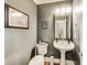 This home features a powder room with grey walls, a decorative mirror, and a pedestal sink at 12437 Meeting House Rd, Carmel, IN 46032