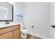 Bathroom with wood vanity, sink, toilet, and bronze fixtures at 13406 Vickery Ridge Dr, Fishers, IN 46037