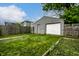 View of fenced backyard with garage and grass at 1418 Olive St, Indianapolis, IN 46203
