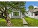 Charming gray home featuring a well-maintained lawn and mature tree, creating curb appeal at 1418 Olive St, Indianapolis, IN 46203