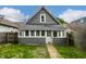 Exterior view of home with enclosed porch, green lawn and fenced yard at 1418 Olive St, Indianapolis, IN 46203