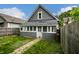 Charming home exterior with enclosed porch, fenced yard and brick path at 1418 Olive St, Indianapolis, IN 46203