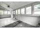 Light-filled sunroom with ceiling fan, paneled walls, and multiple windows at 1418 Olive St, Indianapolis, IN 46203