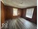 Bedroom with wood-look flooring, wood paneling, and natural light at 1527 Main St, Beech Grove, IN 46107