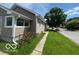 Side-angle shot of the single-Gathering home, featuring tidy landscaping and street view at 1527 Main St, Beech Grove, IN 46107
