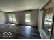 Bright living room with wood-look floors and gray walls illuminated by natural light at 1527 Main St, Beech Grove, IN 46107