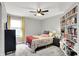 Comfortable bedroom with ceiling fan, neutral walls, and a bookcase filled with books at 158 Handley St, Indianapolis, IN 46222