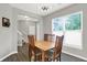 Charming dining room filled with natural light from a large window offers seating for six and stylish light fixture at 158 Handley St, Indianapolis, IN 46222