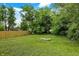 Spacious backyard featuring lush green grass, mature trees, and a wood fence, creating a serene outdoor space at 1722 Dawson St, Indianapolis, IN 46203