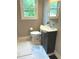 A bathroom featuring a vanity, toilet, and window with natural light, with marble-patterned flooring at 1722 Dawson St, Indianapolis, IN 46203