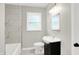 Bathroom with tiled shower, modern vanity, toilet and large window for natural light at 1722 Dawson St, Indianapolis, IN 46203