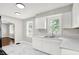 Well-lit kitchen with white cabinetry, marble countertops, and a view into the connecting living room at 1722 Dawson St, Indianapolis, IN 46203