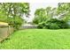 Large backyard featuring a well-maintained lawn, wooden fence, some trees, and neighbor's house at 1730 N Graham Ave, Indianapolis, IN 46218