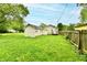 View of the home's spacious backyard featuring a wooden fence and green grass at 1730 N Graham Ave, Indianapolis, IN 46218