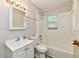 Clean bathroom with white fixtures, a sink, toilet, tub, and a window at 1730 N Graham Ave, Indianapolis, IN 46218