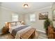 Staged bedroom featuring gray walls, plank flooring, a ceiling light, and two windows at 1730 N Graham Ave, Indianapolis, IN 46218