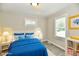 Staged bedroom with white and blue decor, light gray walls, plank flooring, and a window at 1730 N Graham Ave, Indianapolis, IN 46218