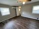 Bedroom with wood-look floors, ceiling fan, and dual windows for natural light at 1730 N Graham Ave, Indianapolis, IN 46218
