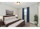 Staged bedroom featuring gray walls, plank flooring, a ceiling light, and a window at 1730 N Graham Ave, Indianapolis, IN 46218