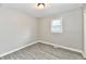 Bedroom featuring light gray walls, plank flooring, a ceiling light, and a window at 1730 N Graham Ave, Indianapolis, IN 46218