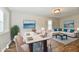 Staged dining room and living room showcasing an elegant dining set and a comfortable white sofa with blue pillows at 1730 N Graham Ave, Indianapolis, IN 46218