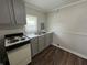 Kitchen featuring a white stove, sink, and modern countertop with updated flooring at 1730 N Graham Ave, Indianapolis, IN 46218