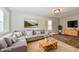 Comfortable living room featuring a gray sectional sofa, wood-look floors, and ample natural light at 1730 N Graham Ave, Indianapolis, IN 46218