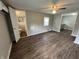 Living room with wood-look floors, ceiling fan, and doors to the bathroom and kitchen at 1730 N Graham Ave, Indianapolis, IN 46218