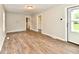 Spacious living room with neutral walls, wood-look flooring, and an open doorway to another room at 1730 N Graham Ave, Indianapolis, IN 46218