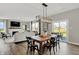 Open-concept dining area featuring a wooden table with black chairs and a modern light fixture at 19843 Moorpark Lndg, Noblesville, IN 46062