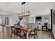 Well-lit dining room with wood flooring, a wooden table, and a view into the living area at 19843 Moorpark Lndg, Noblesville, IN 46062