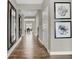 Spacious hallway featuring wood flooring and large framed art and mirrors at 19843 Moorpark Lndg, Noblesville, IN 46062