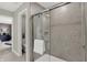 Modern shower with gray tile surround and sliding glass doors, visible from bedroom doorway at 19843 Moorpark Lndg, Noblesville, IN 46062