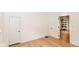 Open bedroom with hardwood floors, white trim, and two open doorways to other rooms at 201 N 11Th St, Elwood, IN 46036