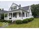 Inviting home features a covered porch, mature landscaping, and classic architecture at 201 N 11Th St, Elwood, IN 46036