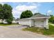 Three-car garage with white doors and a driveway for parking at 201 N 11Th St, Elwood, IN 46036