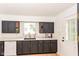 Galley kitchen with black cabinets, light countertops, and gold hardware at 201 N 11Th St, Elwood, IN 46036