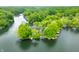 An aerial view shows homes nestled among trees and next to a tranquil lake at 242 W Warford Dr, , IN 46164