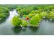 An aerial view shows homes nestled among trees and next to a tranquil lake at 242 W Warford Dr, , IN 46164
