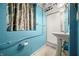 Small blue bathroom featuring a shower stall, sink, and a window with curtains, painted in bright, bold colors at 242 W Warford Dr, , IN 46164